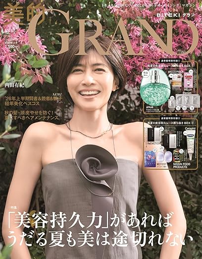 Magazine cover featuring a smiling woman in a strapless gray dress with a black fabric flower, pink blossoms in the background; product ads on the right side.